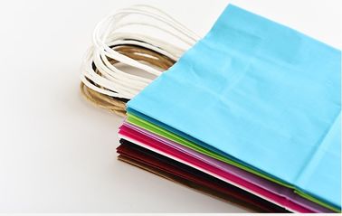 Il colore blu ha stampato il logo di Customzied dei sacchi di carta di Kraft con la maniglia di carta torta fornitore